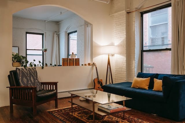 the interior of a living room with a guitar and a view to another room