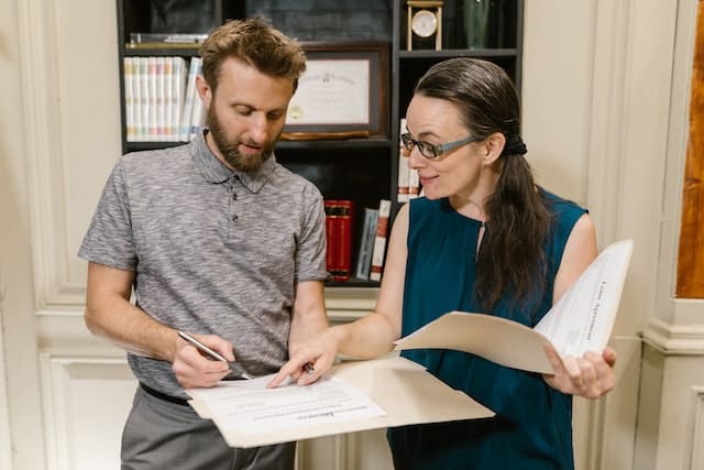 two people looking at folders with papers inside them