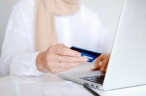 person entering credit card details into a laptop