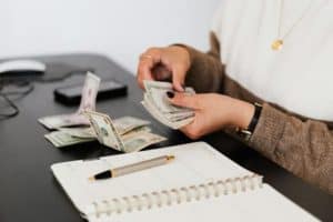 person counting money at a desk