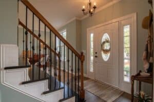 inside of a house with white front door and staircase