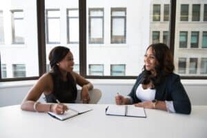 two people in an office jotting down notes