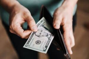 person taking cash out of their pocket