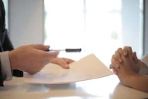 person handing over pen and lease